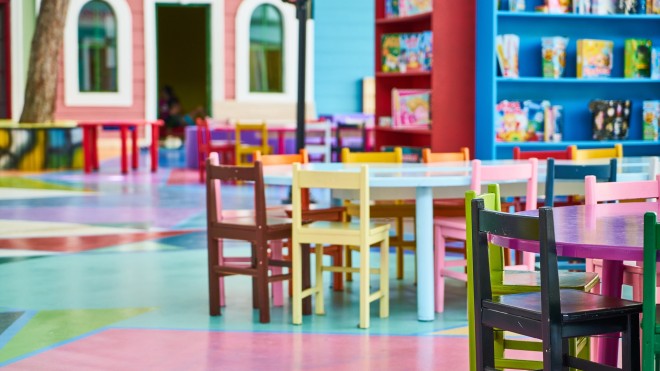 Kindergartenzimmer mit bunten Stühlen und Tischen
