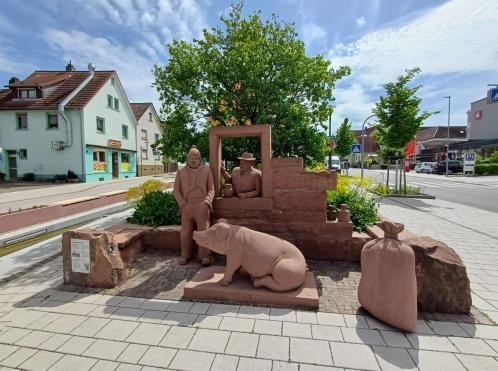 Skulpturengruppe Waaghäusel Wiegemeister mit Waage, auf der ein Schwein sitzt