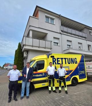 Bürgermeister Markus Bechler mit ProMedic Mitarbeitern vor einem Einsatzwagen